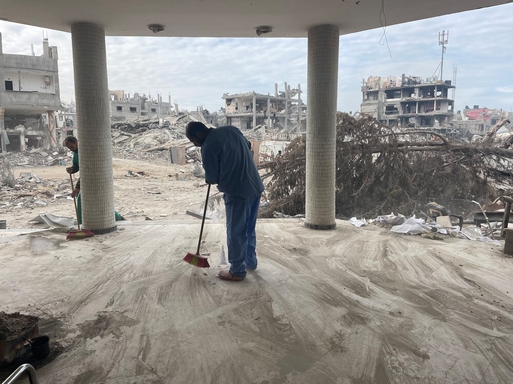 man cleaning the rubble inside the emirati hospital in rafah city southern gaza palestine